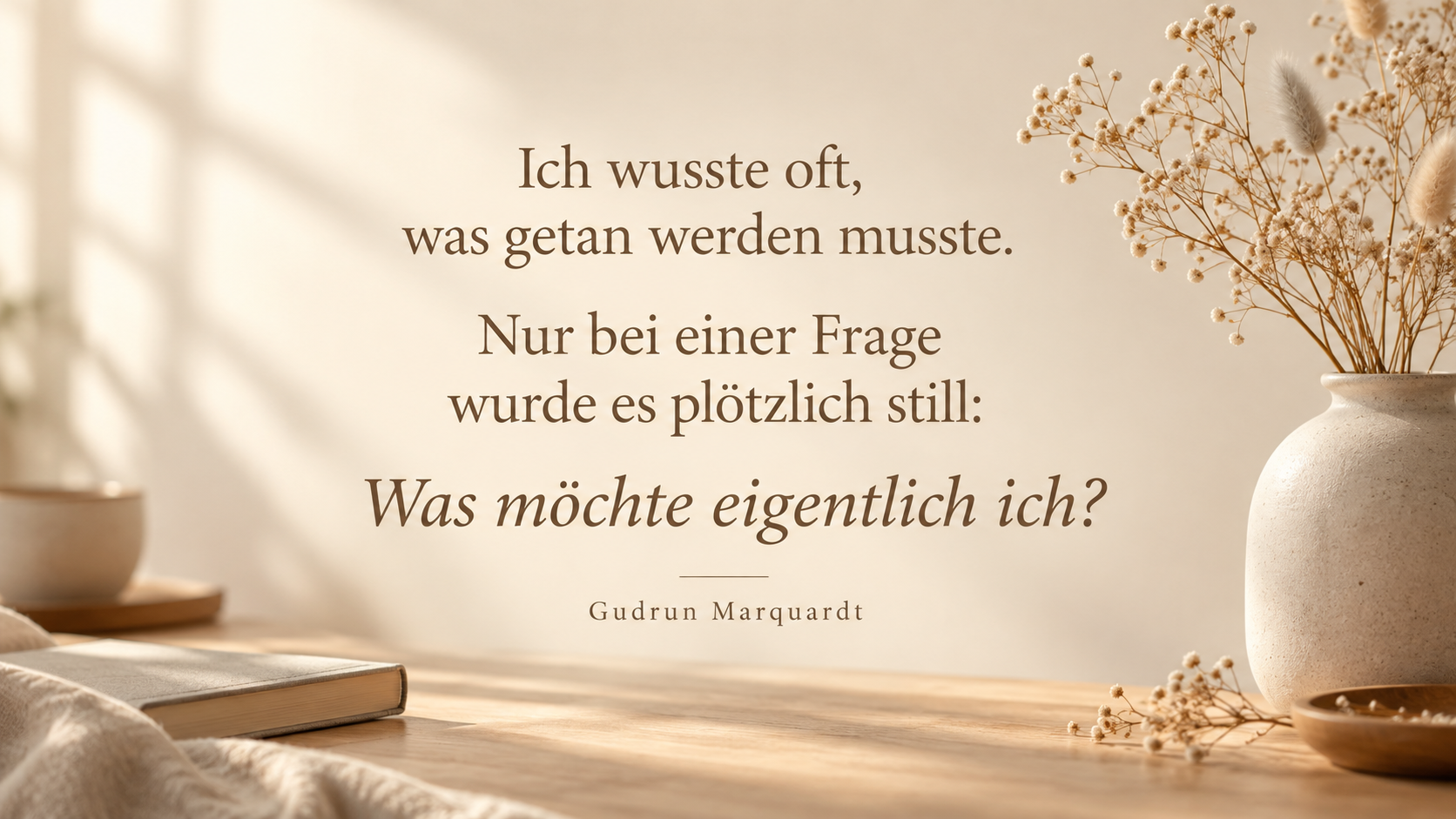 Beiges Textbild mit Vase, Trockenblumen, Buch und dem Zitat „Was möchte eigentlich ich?“ von Gudrun Marquardt.